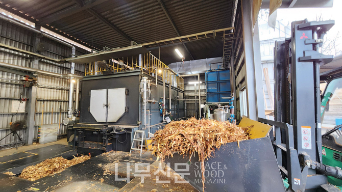 건조기 보일러에 나무껍데기가 연료로 투입되고 있다.